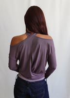 Rear view of a model wearing the Orchid Dahlia Top by Lunetti with blue jeans, showcasing the softly draped back neckline and relaxed long-sleeve fit.