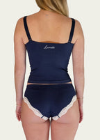 Rear view of a model wearing the Midnight Navy Luna Cami and matching briefs by Lunetti, highlighting the straight back neckline, adjustable straps, and embroidered Lunetti branding.