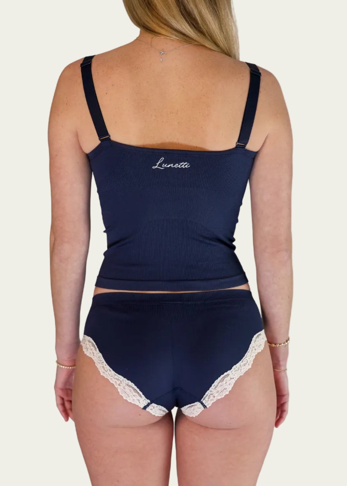 Rear view of a model wearing the Midnight Navy Luna Cami and matching briefs by Lunetti, highlighting the straight back neckline, adjustable straps, and embroidered Lunetti branding.