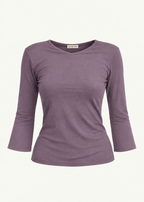 Front product view of the Orchid Willow Top by Lunetti against an ivory background, featuring soft lavender-purple bamboo jersey, a V-neckline, fitted silhouette, gently flared three-quarter sleeves, and a signature Lunetti neck label.