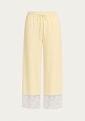 Light yellow wide-leg cropped pants with a white lace trim at the hem and a drawstring waist, shown on a plain light background.