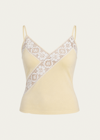 A pale yellow camisole top with thin straps and a diagonal white lace panel across the chest, shown on a light gray background.