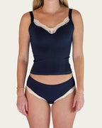 Front view of model wearing the Lunetti Luna Top and Luna Brief in Midnight Navy with white lace trim.