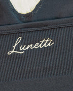 Close-up detail of the white Lunetti embroidery on the ribbed waistband of the Luna Top in Midnight Navy.